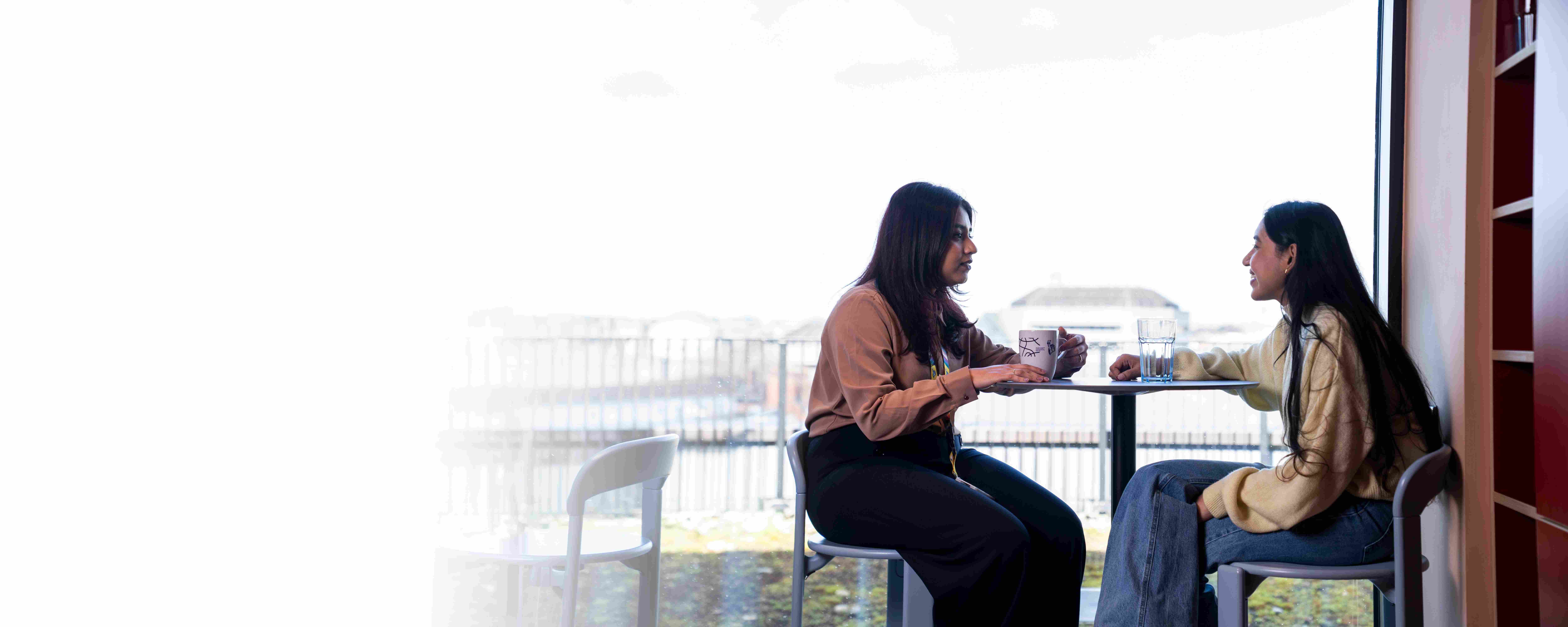 Two employees having a coffee in the office kitchen