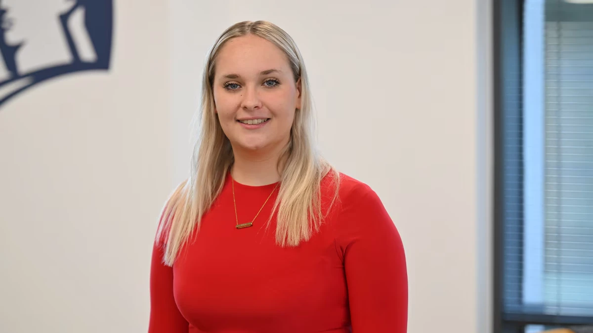 Brea, Apprentice Software Engineer, smiling in Liberty IT office