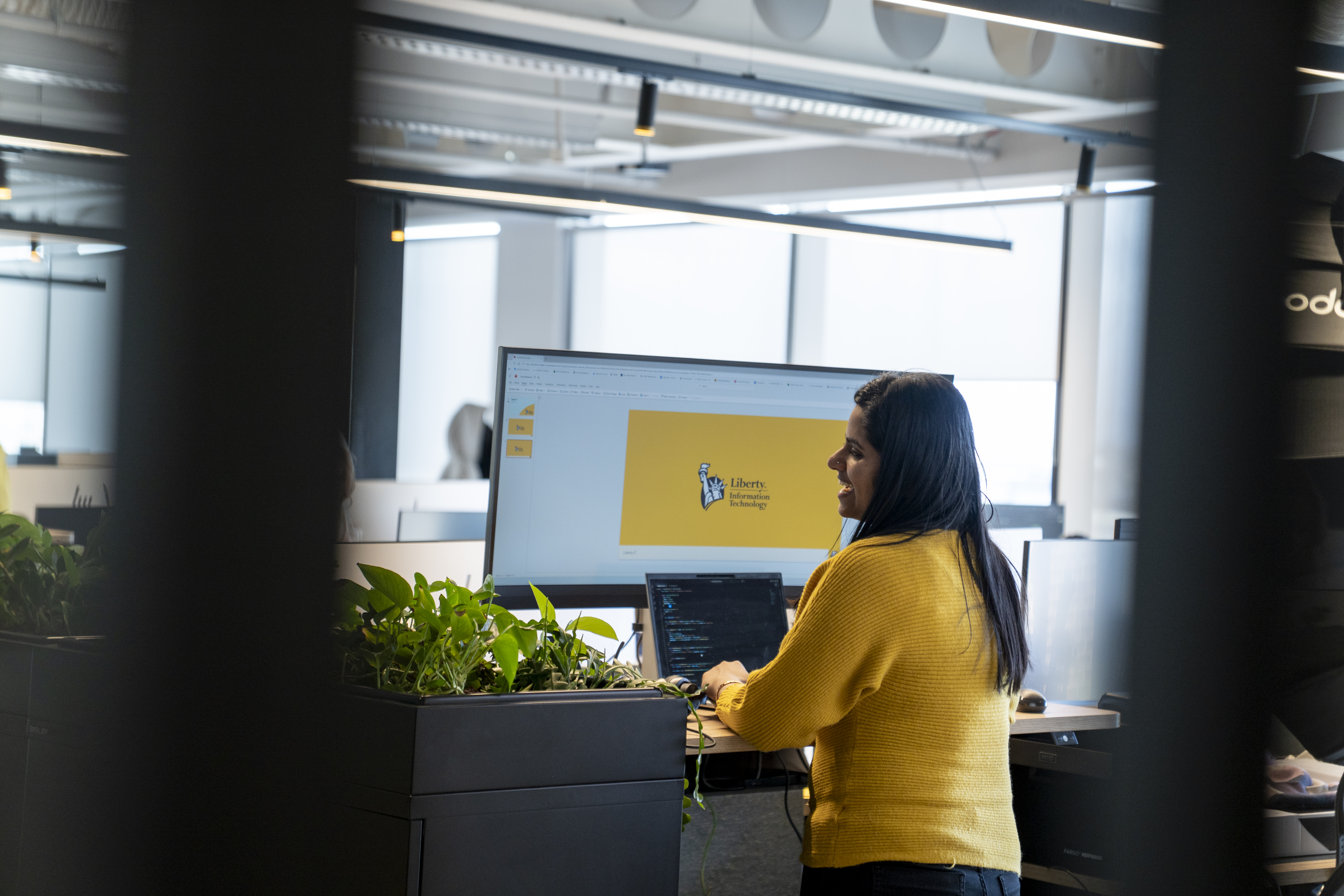 Employee working at a desk in the Liberty IT Dublin office.