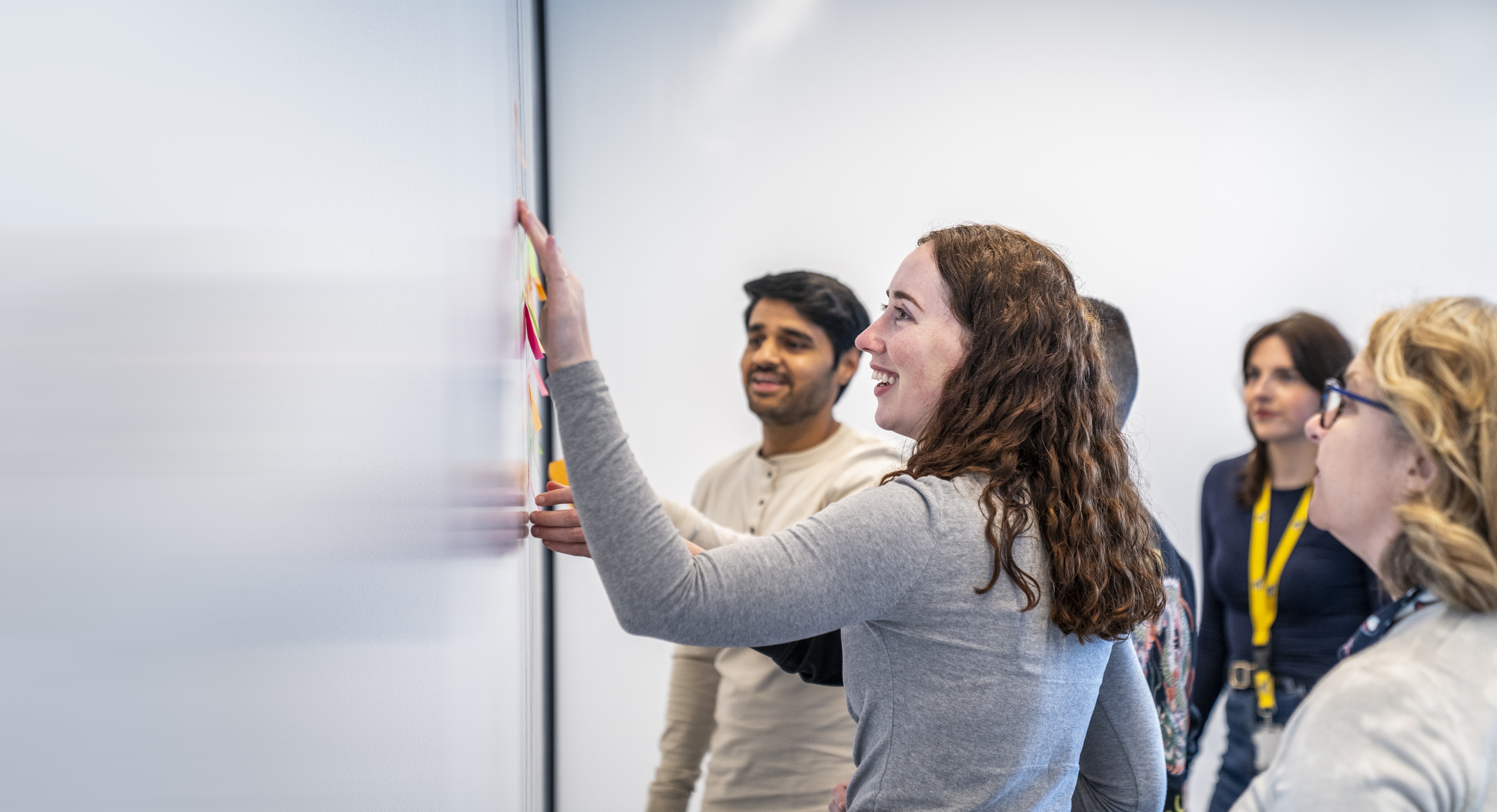 Employees sharing ideas at a whiteboard.