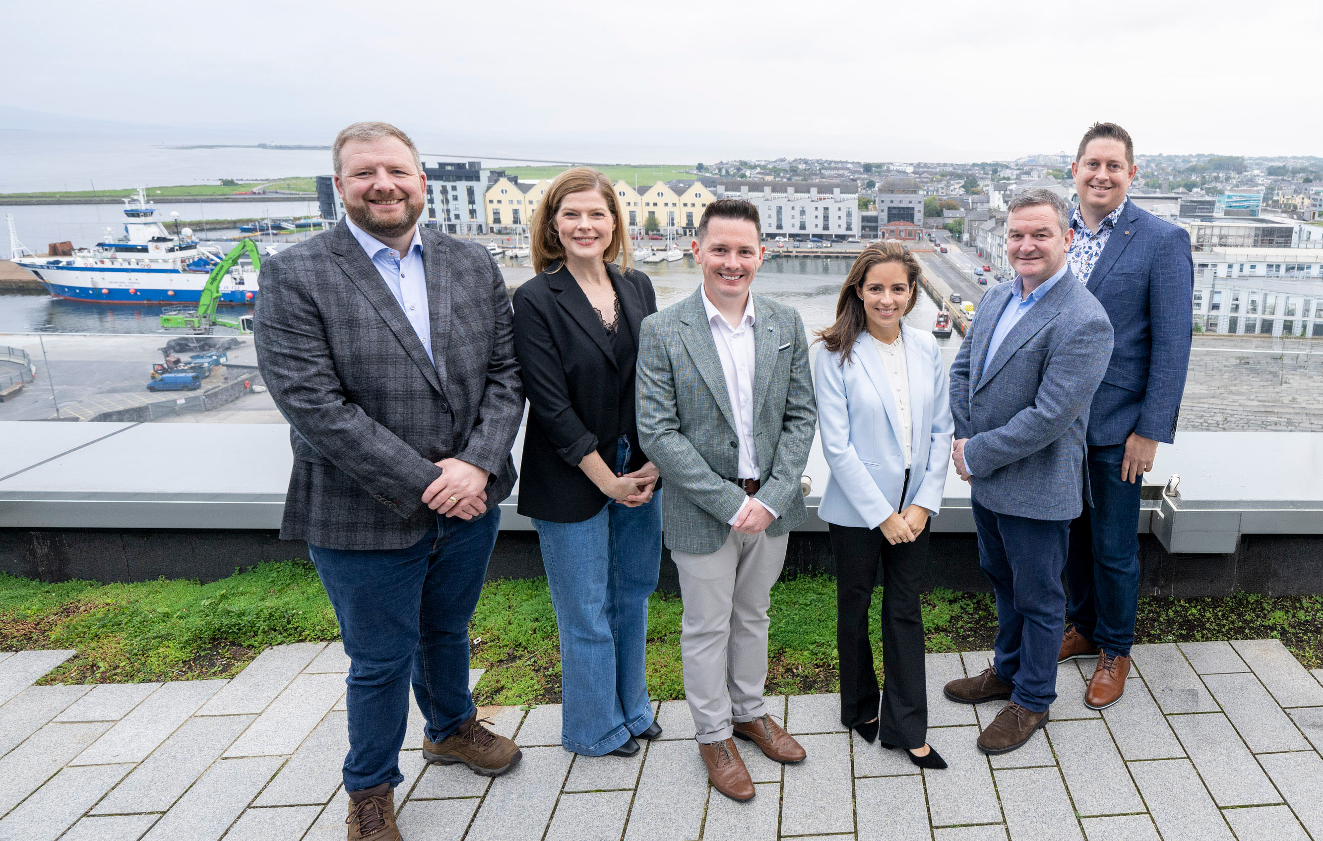Eight Liberty employees smiling on balcony